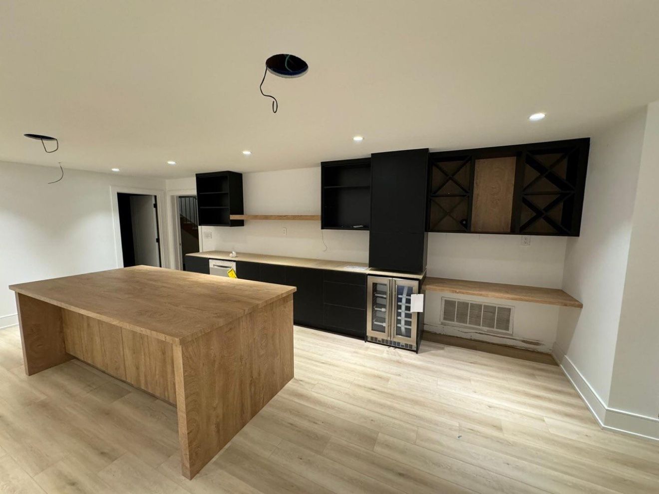 Basement bar in black and oak with waterfall island and wine fridge