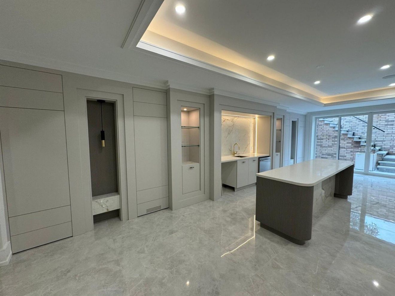 Basement recreation room with panelled walls, wet bar and fluted island