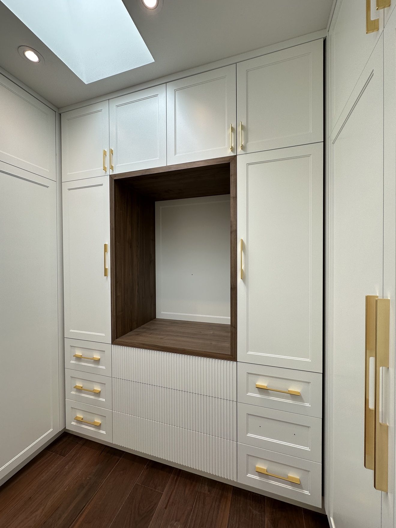 Dressing room niche in walnut with fluted drawers and brass pulls
