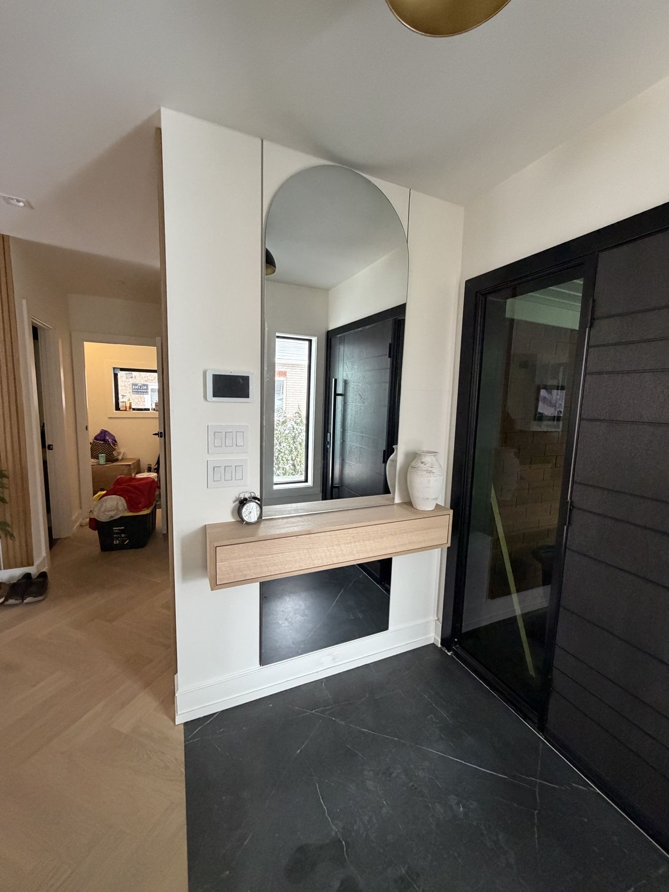 Entry with full-height arched mirror and floating oak console drawer