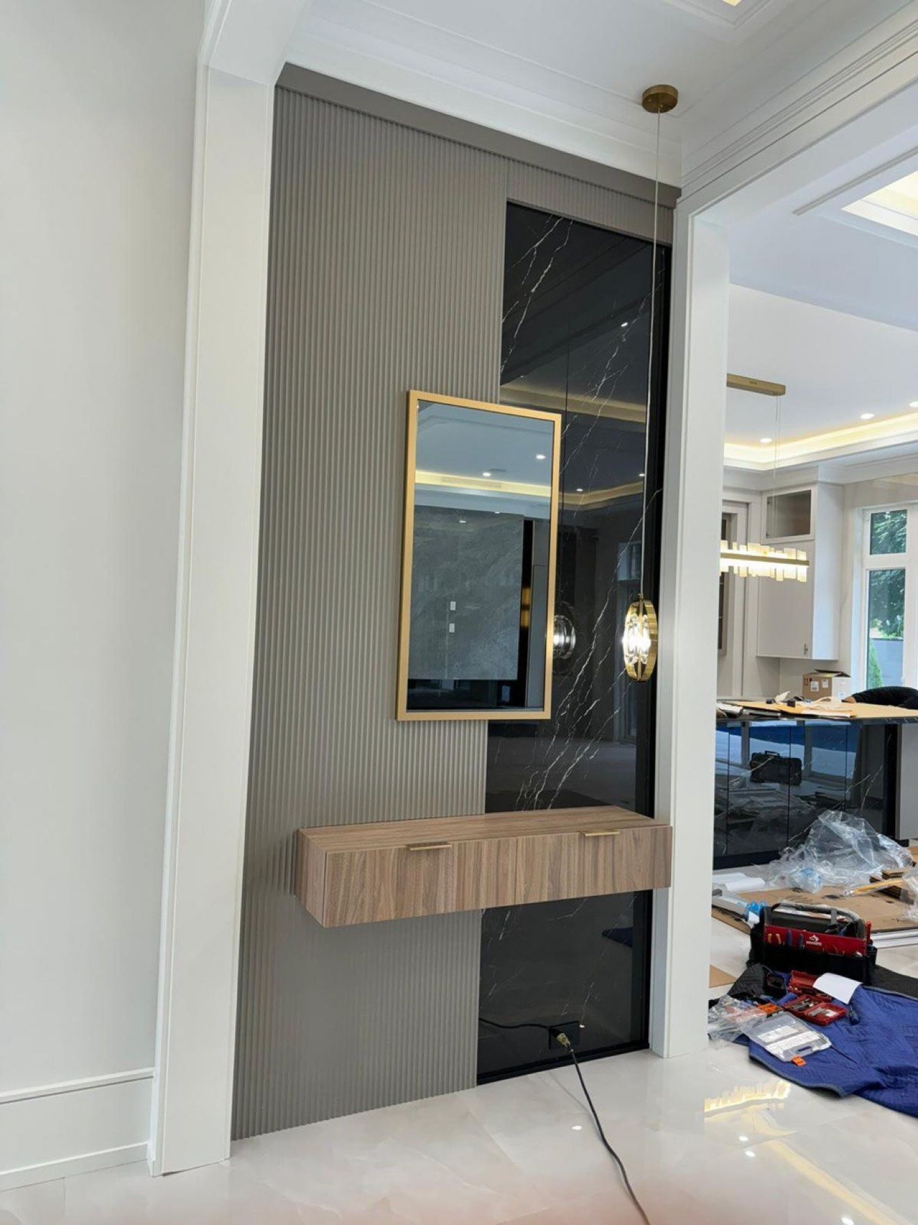 Entry console wall with fluted panels, black marble and floating walnut drawer