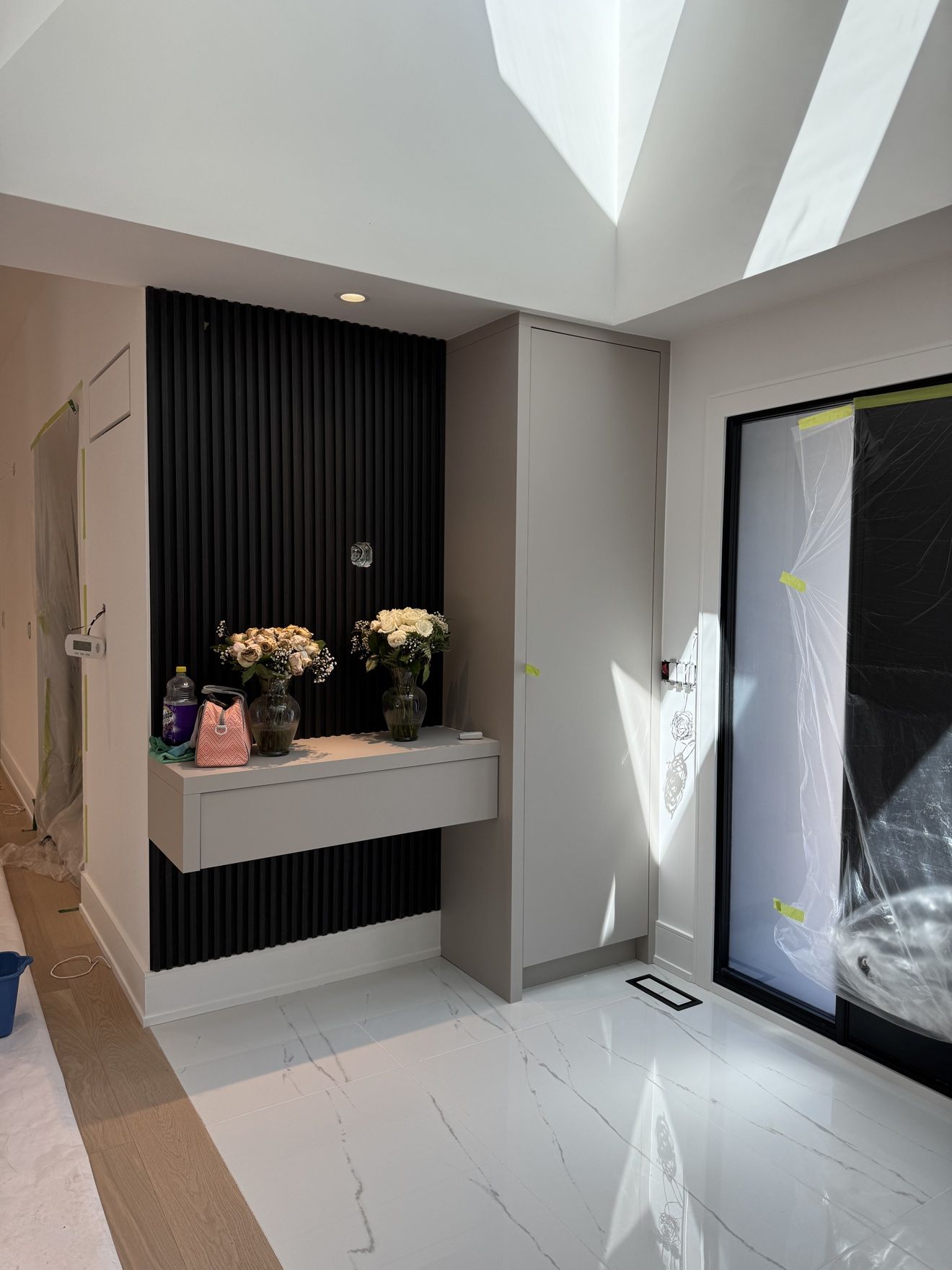 Entry nook with black fluted wall, floating drawer and tall storage cabinet