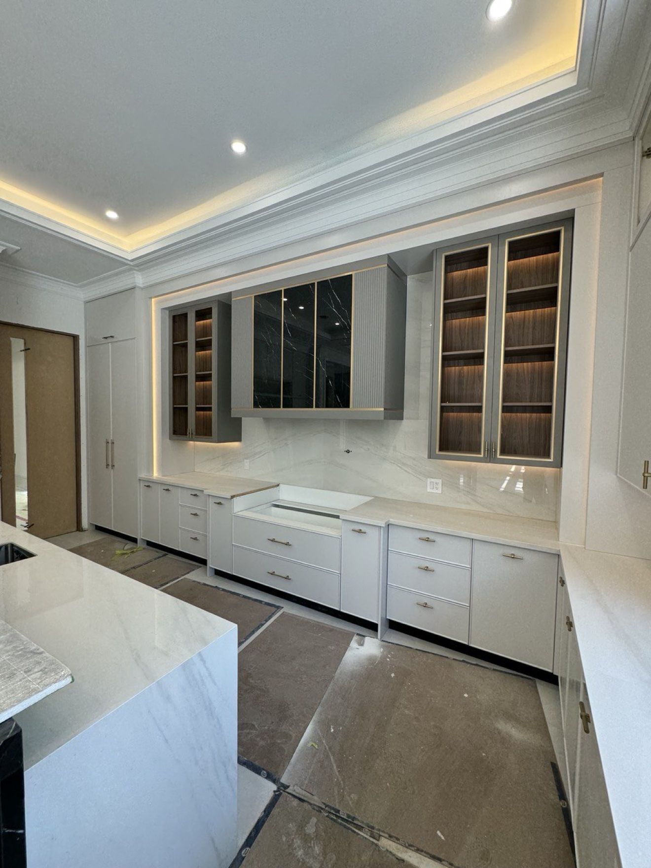 Luxury kitchen with LED-lit glass cabinets and cove ceiling