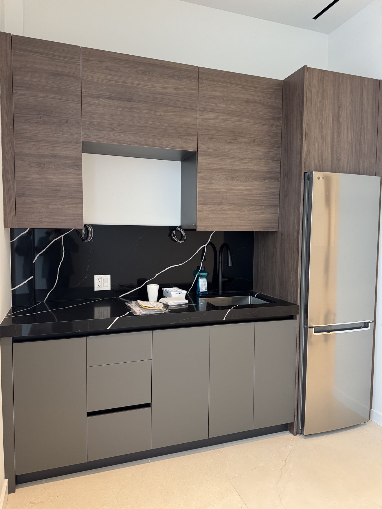 Kitchenette cabinetry detail with black marble backsplash