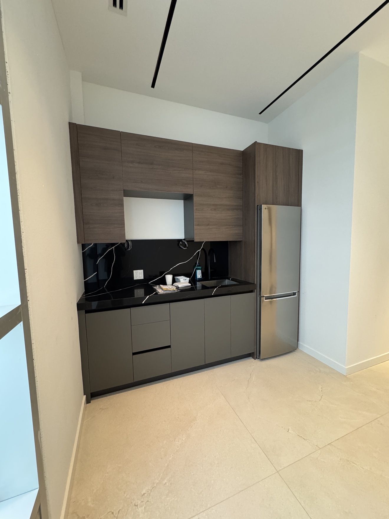 Office kitchenette in walnut and grey with black marble