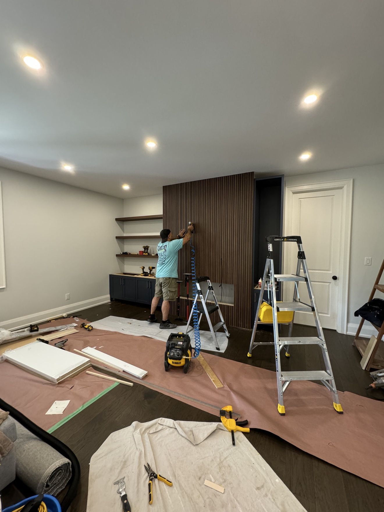 Installing a walnut slat media wall with navy cabinets