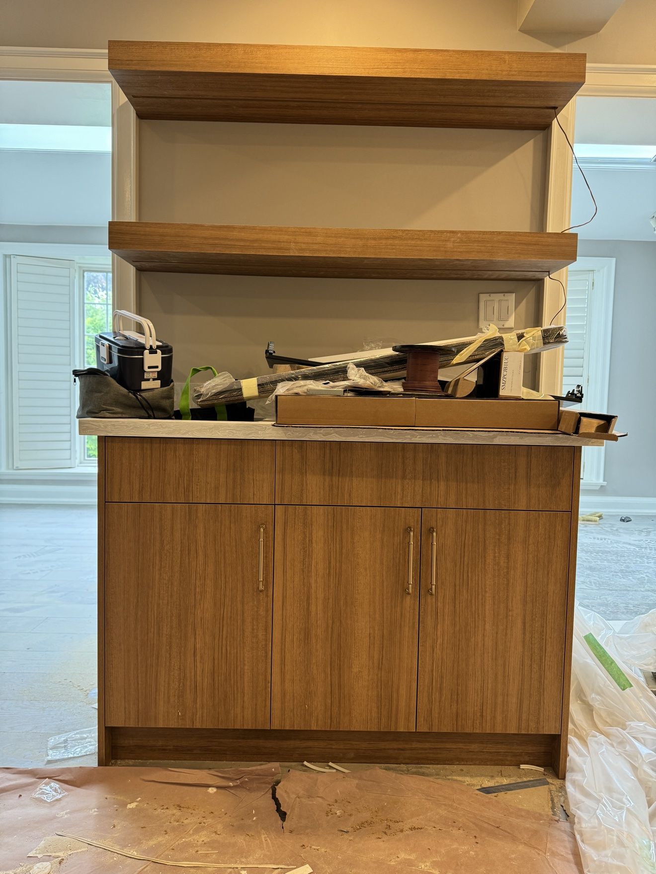 Walnut servery cabinet with thick floating shelves and brass pulls