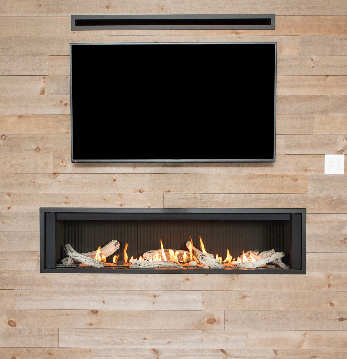 Valor L3 — frameless linear gas fireplace beneath a TV on a wood wall