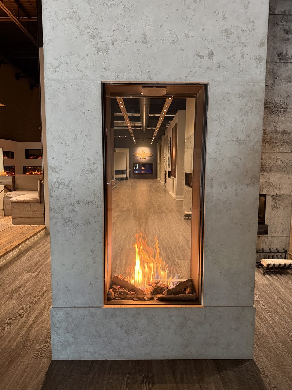 A tall see-through gas fireplace photographed in the showroom